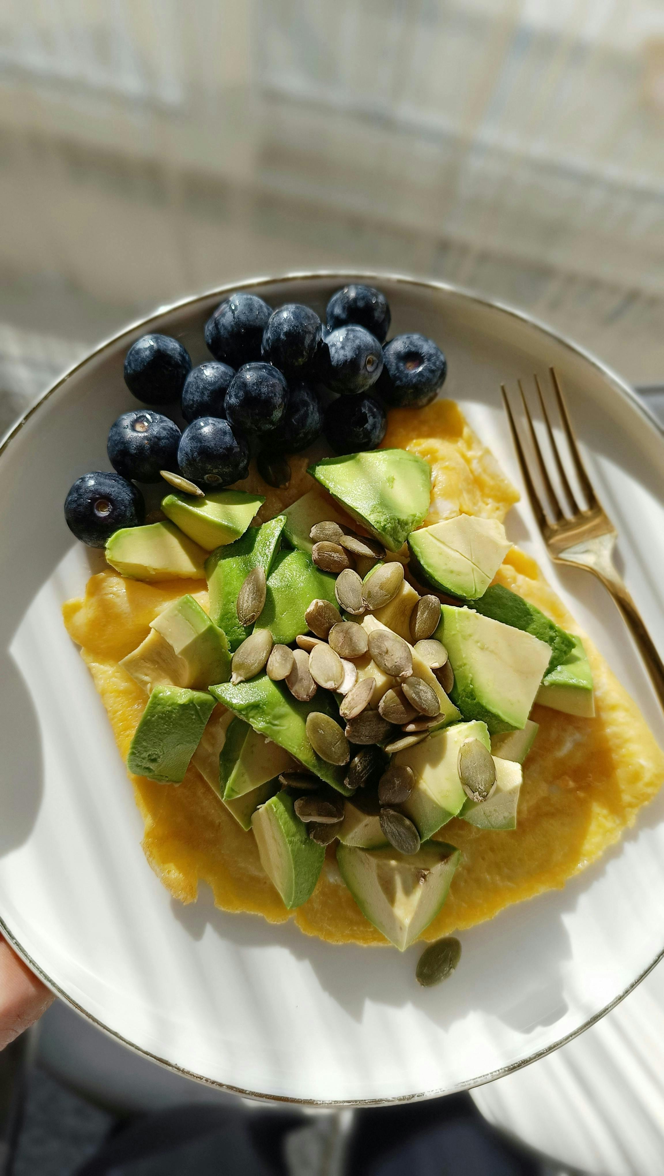 Healthy breakfast bowl with omelet, avocado slices and seeds
